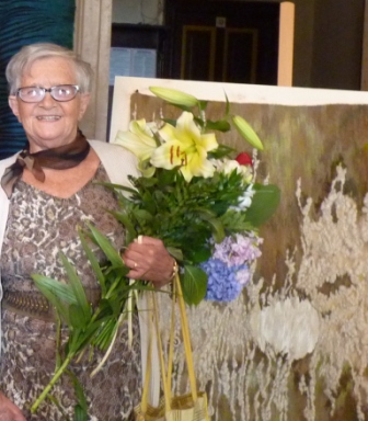 Artystka Jadwiga Wosik z kwiatami na tle gobelinu w Pałacu Raczyńskich w Złotym Potoku